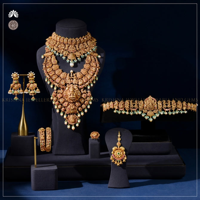 Bridal Gold Jewellery Set with Divine Carvings & Precious Gemstones